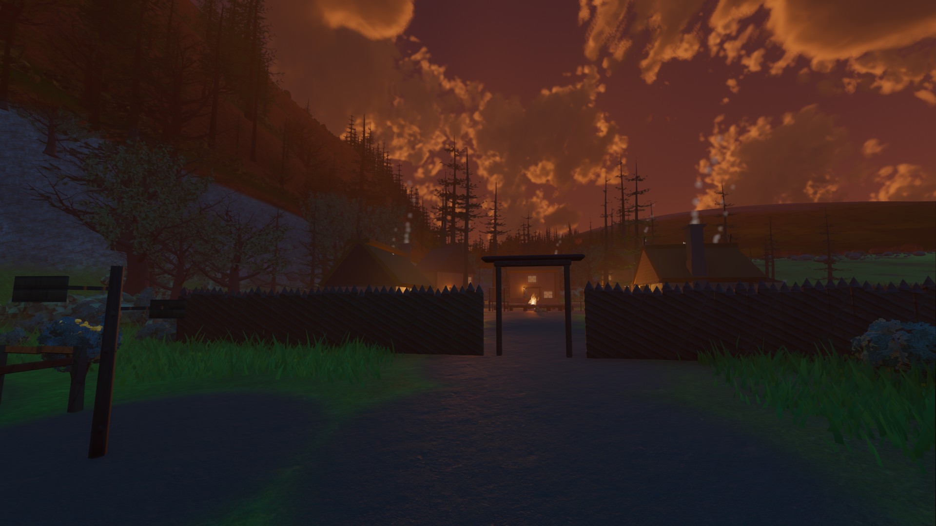 The village at sunset under saturated orange clouds against a deep red sky, the ground almost black